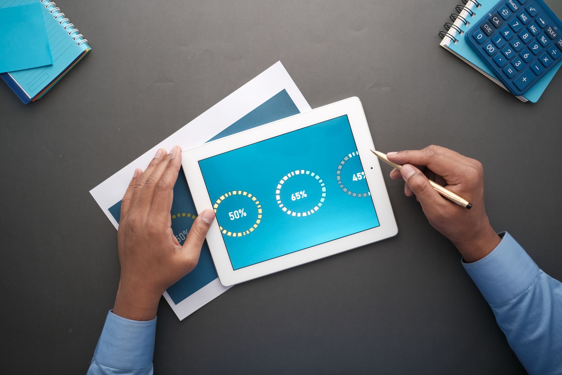 Small business owner reviewing social media analytics on a tablet at a desk
